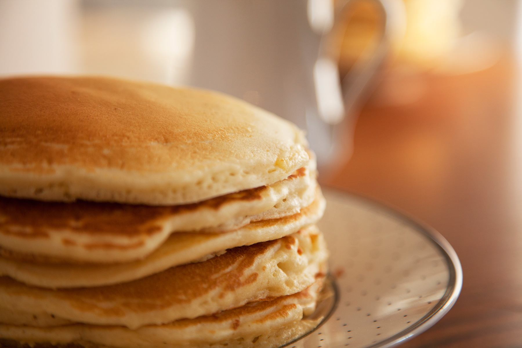 A plate with a short stack of golden pancakes.