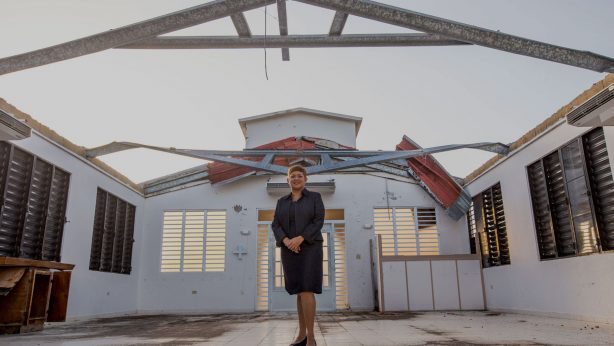 Pastora Milly Cortes stands in Iglesia Cristian (Discipulos de Cristo) La Grama, which has no roof and sustained other damage during Hurricane Maria.