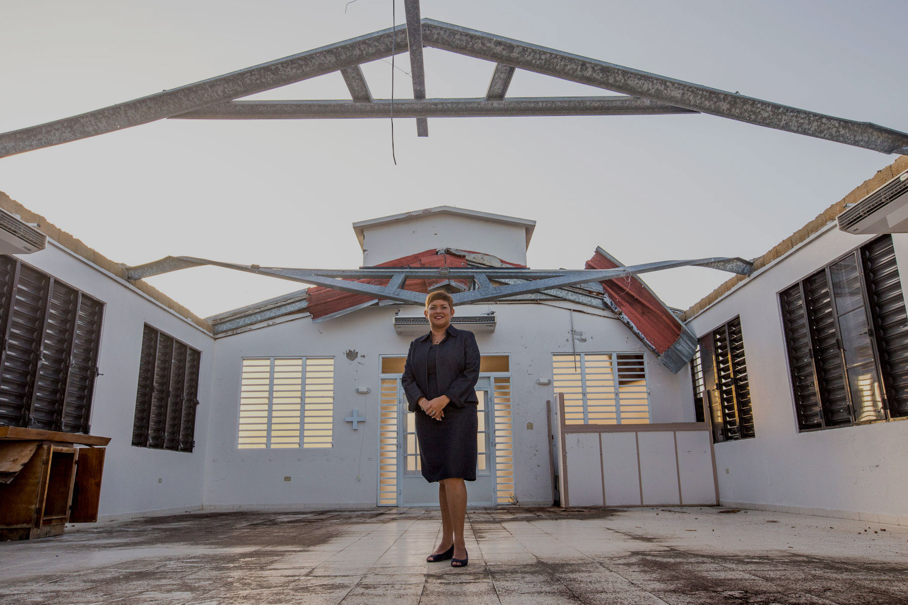 Pastora Milly Cortes stands in Iglesia Cristian (Discipulos de Cristo) La Grama, which has no roof and sustained other damage during Hurricane Maria.